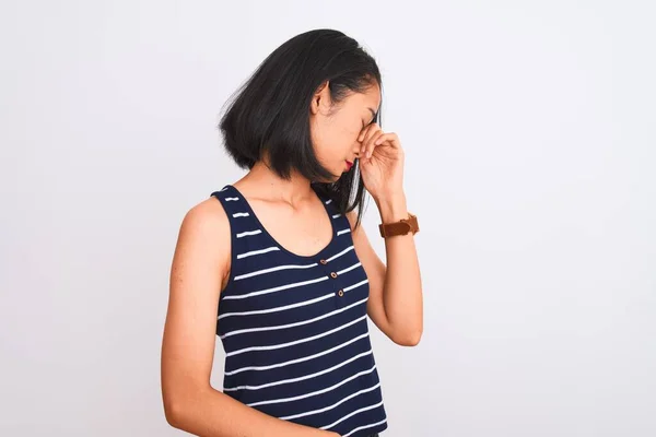 年轻的中国女人穿着条纹T恤 站在孤立的白色背景上 疲惫地揉揉鼻子和眼睛 感觉疲劳和头痛 压力和挫败感概念 — 图库照片