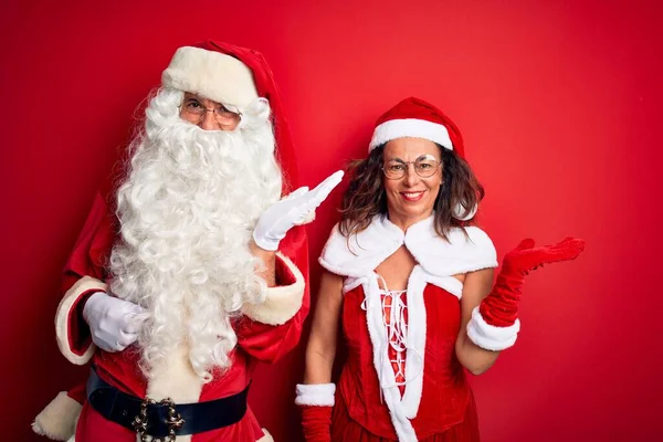 Paar Mittleren Alters Weihnachtsmannkostüm Und Mit Brille Vor Isoliertem Rotem — Stockfoto