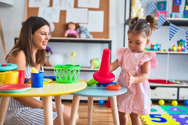 Junge Schöne Lehrerin Und Kleinkind Bauen Pyramide Mit Reifen Auf — Stockfoto