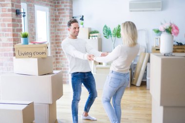 Karton kutular etrafında yeni evde dans genç güzel çift