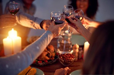 Aile ve arkadaşlar Noel arifesini geleneksel yemek ve dekorasyonla birlikte evde yemek yiyorlar. Hep birlikte masaya oturuyorlar.