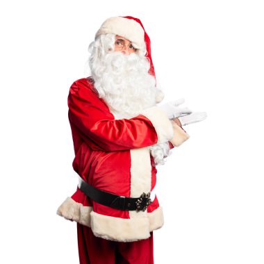 Orta yaşlı yakışıklı adam, Noel Baba kostümü ve sakal takmış, avuçları açık, fotokopi alanını gösteren, gülümseyerek mutlu bir gülümseme sunan,