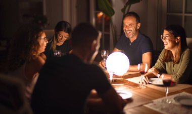 Güzel bir aile akşam yemeğinde terasta konuşuyor ve gülümsüyor