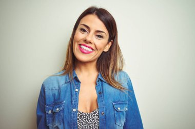 Genç güzel kadın yüzünde mutlu ve serin bir gülümseme ile izole arka plan üzerinde duran. Şanslı kişi.