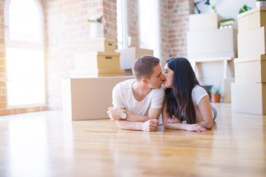 Genç güzel çift karton kutular etrafında yeni evde yatarken