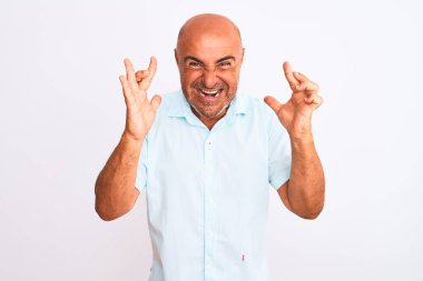 İzole edilmiş beyaz arka plan jestleri yapan, umut ve gözler kapalı gülümseyen orta yaşlı, yakışıklı bir adam. Şans ve batıl inanç..