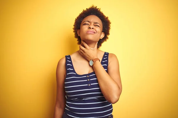 美しいアフリカ系アメリカ人の女性は 隔離された黄色の背景に夏のTシャツを着て痛みを伴う首に触れます インフルエンザのための喉の痛み 雲と感染症 — ストック写真