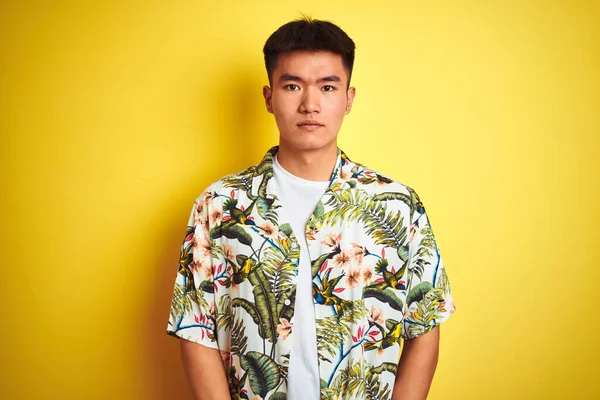 顔に深刻な表情で隔離された黄色の背景に夏のシャツを着て休日のアジアの中国人男性 シンプルで自然なカメラを見て — ストック写真