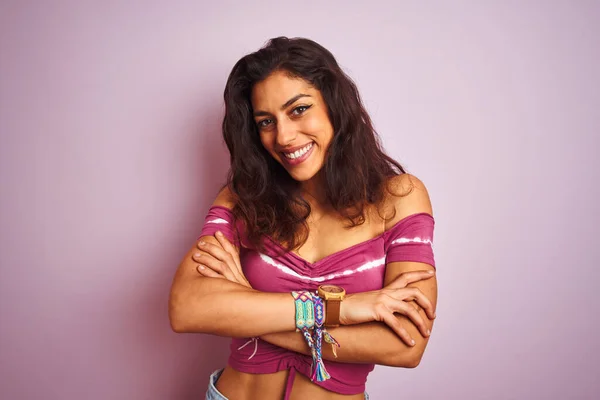 Young beautiful woman wearing casual t-shirt standing over isolated pink background happy face smiling with crossed arms looking at the camera. Positive person.