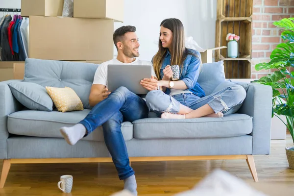 Ungt par flyttar till ett nytt hem avkopplande sitter på soffan u — Stockfoto