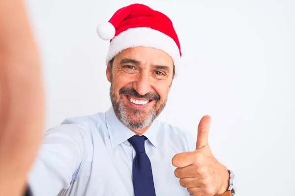 中世のビジネスマン身に着けているクリスマスの帽子作ります自画撮り上の隔離された白い背景幸せなで大きな笑顔を行いますOkサイン 親指アップとともに指 優れたサイン — ストック写真