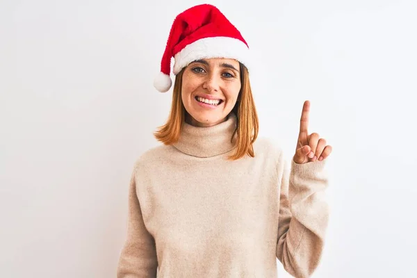 Hermosa Pelirroja Con Sombrero Navidad Sobre Fondo Aislado Mostrando Apuntando —  Fotos de Stock
