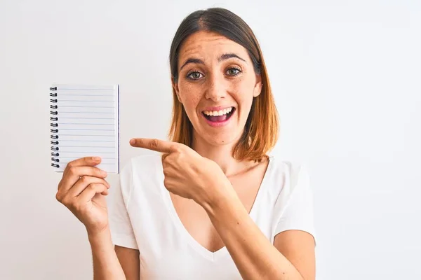 Hermosa Pelirroja Mostrando Cuaderno Blanco Sobre Fondo Aislado Muy Feliz —  Fotos de Stock