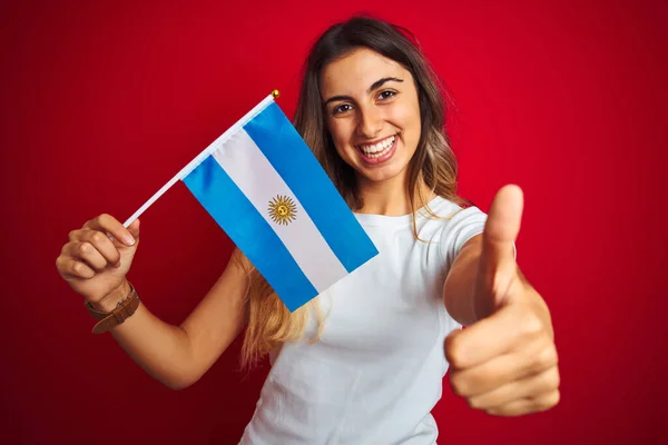 Молода Красива Жінка Тримає Прапор Аргентину Над Червоним Ізольованим Тлом — стокове фото