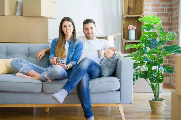 Joven pareja mudándose a un nuevo hogar relajante sentado en el sofá w —  Fotos de Stock