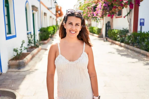 Young beautiful woman at the colorful village of Puerto de Mogan, smiling happy at the street on summer holidays