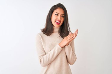 Balıkçı yaka kazak giyen güzel Çinli kadın izole edilmiş beyaz arka plan üzerinde duruyor alkışlıyor ve mutlu ve neşeli, gururlu elleri birlikte alkışlıyor.