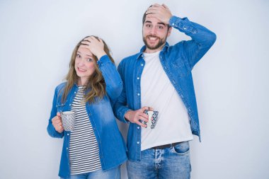 Genç ve güzel bir çift, beyaz izole arka planda bir fincan kahve içiyorlar. Kafa kafaya verip strese giriyorlar. Utanç ve şaşkınlık içinde, sinirli ve hayal kırıklığına uğramış bir haldeler. Hata için korku ve üzüntü.