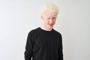 Siyah tişörtlü genç, albino sarışın adam izole edilmiş beyaz arka planda duruyor. Seksi bir ifadeyle kameraya bakıyor. Neşeli ve mutlu bir yüzü var..