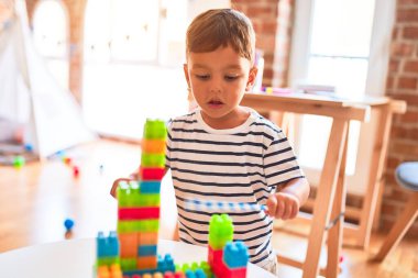 Güzel çocuk anaokulunda inşaat bloklarıyla oynuyor.