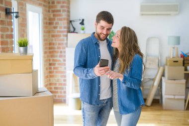 Genç çift cardb etrafında akıllı telefon kullanarak yeni bir eve hareket