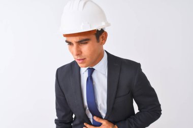 Genç ve yakışıklı mimar takım elbise ve miğfer giyerek izole edilmiş beyaz arka planda midesi üstünde duruyor çünkü hazımsızlık, acı verici bir hastalık kendini iyi hissetmiyor. Ache kavramı.