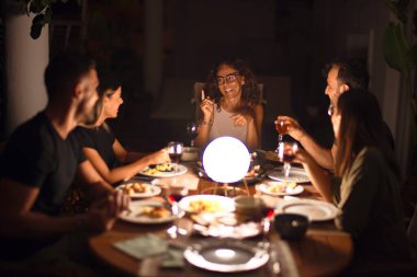 Güzel bir aile akşam yemeğinde terasta konuşuyor ve gülümsüyor