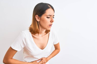 Güzel kızıl saçlı kadın izole edilmiş arka planda, hazımsızlık ve acı veren hastalıklardan dolayı el üstünde beyaz tişört giyiyor. Ache kavramı.