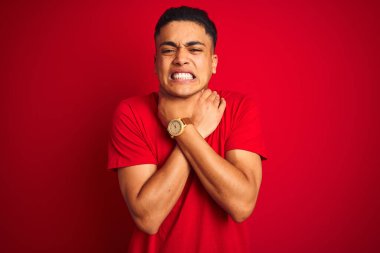 İzole edilmiş kırmızı arka planda dikilmiş tişört giyen genç Brezilyalı adam boğularak öldü diye bağırıyor. Sağlık problemi. Boğulma ve intihar konsepti.