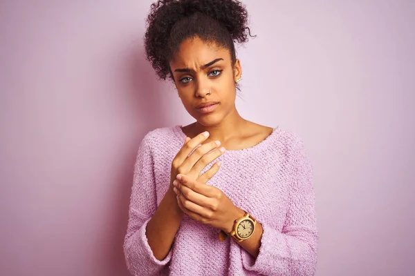 若いアフリカ系アメリカ人の女性は 孤立したピンクの背景の上に立って冬のセーターを身に着けています手や指の痛み 関節炎の炎症 — ストック写真