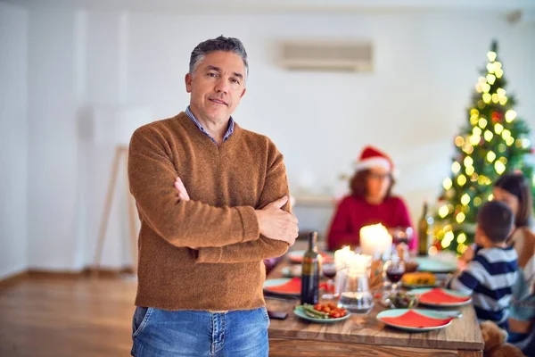 中年ハンサムな男は幸せと自信に満ちて笑顔 自宅で家族と一緒にクリスマスを祝う立ってポーズ — ストック写真