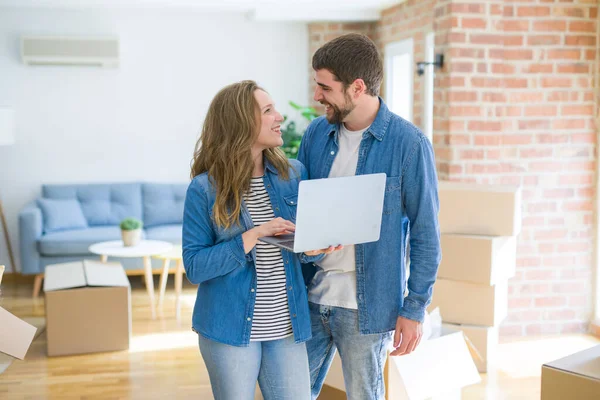 Young couple using computer laptop standing on a room around car