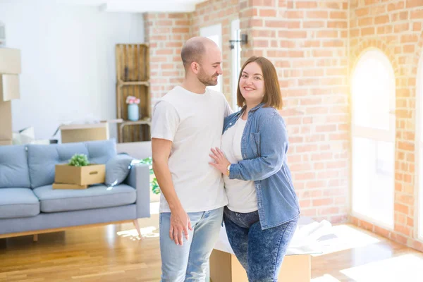 Pareja joven juntos sonriendo feliz mudándose a una nueva casa — Foto de Stock