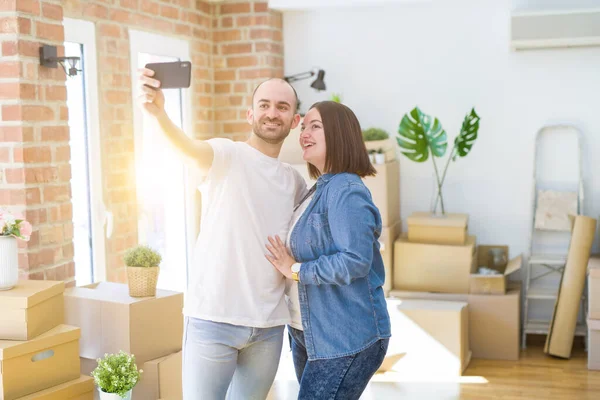 Casal jovem tirando uma foto usando smartphone em nova casa — Fotografia de Stock