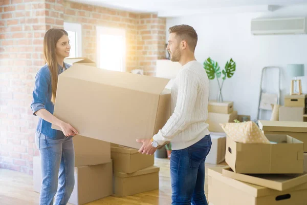 Schönes junges Paar zieht in ein neues Zuhause und hält große Kartons in der Hand — Stockfoto