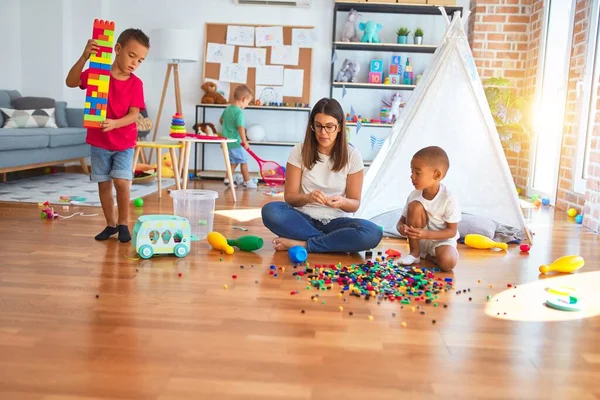 Junge Schöne Lehrerin Und Kleinkinder Spielen Kindergarten Mit Viel Spielzeug — Stockfoto