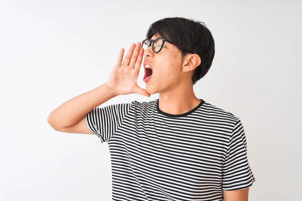 眼鏡とネイビーのストライプのTシャツを着た中国人男性が白い背景の上に立って大声で叫び 口の上に手で横に叫んでいる コミュニケーションの概念 — ストック写真