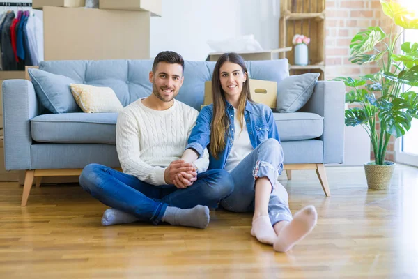 Junges schönes Paar sitzt auf dem Boden der neuen Wohnung, sm — Stockfoto