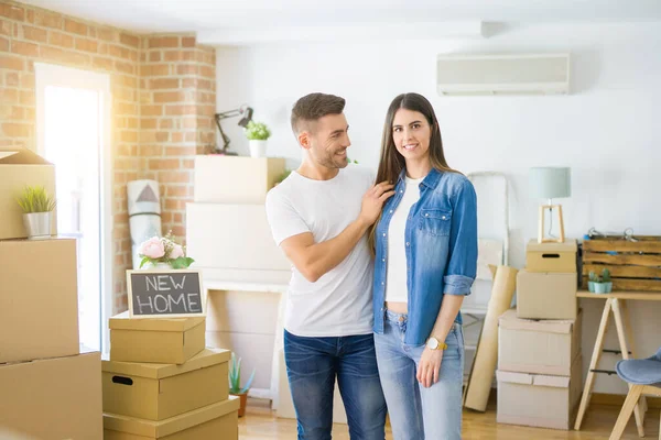 Schönes junges Paar zieht in ein neues Haus und lächelt glücklich arro — Stockfoto