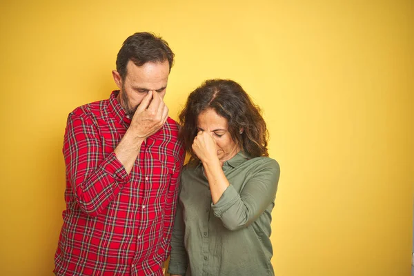 孤立した黄色の背景上の美しい中年のカップルは 疲労や頭痛を感じて鼻や目をこすり疲れ ストレスと欲求不満の概念 — ストック写真