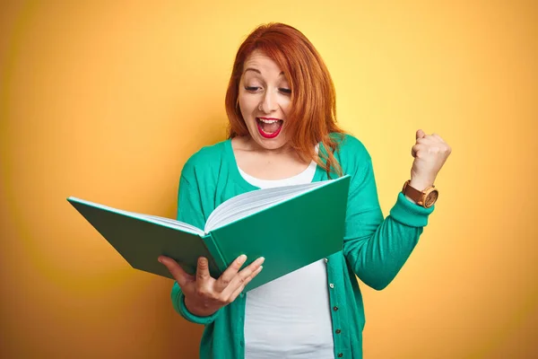 Joven Estudiante Pelirroja Leyendo Libro Verde Sobre Fondo Amarillo Aislado — Foto de Stock