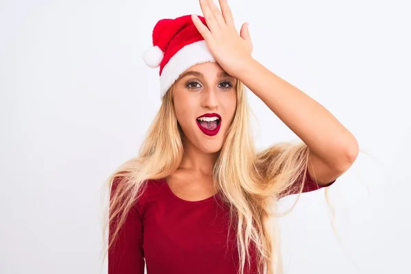 若い美しい女性が誤って エラーを覚えて頭の上に手で驚いて隔離された白い背景にクリスマスのサンタの帽子をかぶって 忘れられた悪い記憶の概念 — ストック写真