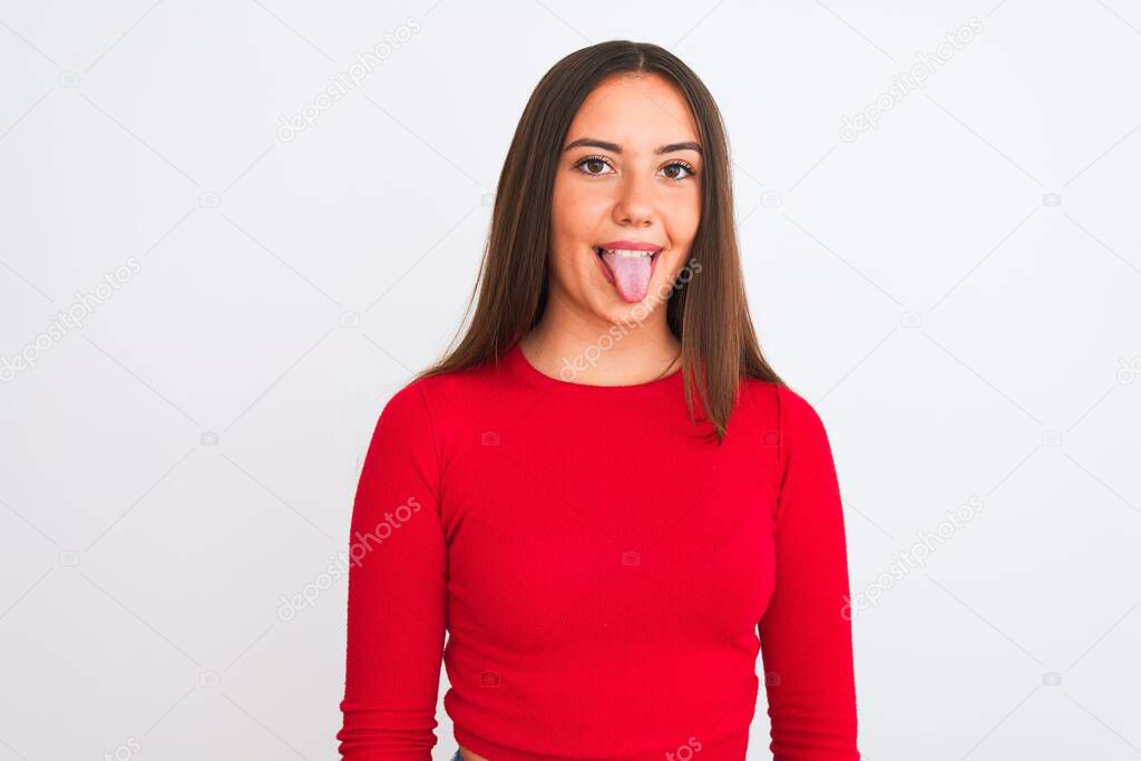 Young beautiful girl wearing red casual t-shirt standing over isolated white background sticking tongue out happy with funny expression. Emotion concept.