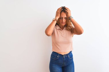 Genç kızıl saçlı kadın, acı ve migrenden dolayı baş ağrısı ve stresten muzdarip, izole edilmiş beyaz bir arka plan üzerinde duruyor. Ellerini başının üstüne koy..