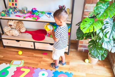 Anaokulunda elinde çalar saatle bekleyen güzel çocuk.
