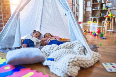 Sevimli bebekler, Tip 'in içinde, anaokulunda sırıtarak battaniyenin üzerine uzanırlar.