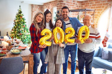 Mutlu ve kendinden emin gülümseyen güzel bir aile. Noel 'i kutlamak için elinde balonlarla dikiliyorum.