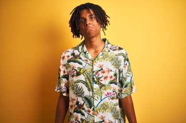 Tatilde sarı arka planda yalnız bırakılmış tişört giyen Afro saçlı adam depresif, sinirli ve korkmuş bir şekilde ağlıyor. Üzücü ifade.