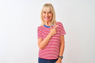 Sıradan çizgili tişört giyen orta yaşlı bir kadın izole edilmiş beyaz arka planda neşeli bir şekilde ayakta duruyor. Yüzünde mutlu ve doğal bir ifade olan bir gülümseme var.