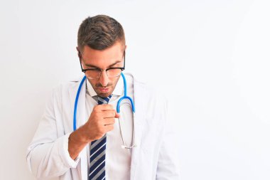 Soyutlanmış arka planda steteskop takan genç yakışıklı doktor kendini iyi hissetmiyor ve soğuk algınlığı veya bronşitin belirtisi olarak öksürüyor. Sağlık hizmetleri kavramı.
